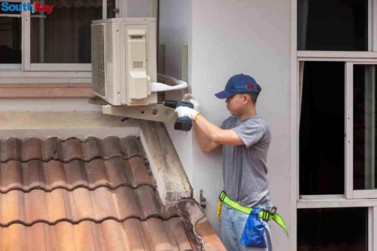 A technician is performing emergency AC repair, adjusting components on an air conditioning unit with a wrench.
