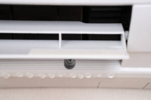 Close-up of a white air conditioner showing signs of a water leak.
