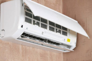 White wall-mounted air conditioner with visible water leak underneath.