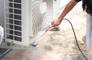 A woman cleans an air conditioner, focusing on the compressor repair process.
