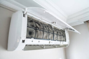 A white wall-mounted air conditioner unit installed on a light-colored wall.