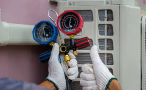 A person cleaning an air conditioner with a brush, demonstrating proper maintenance of AC systems.